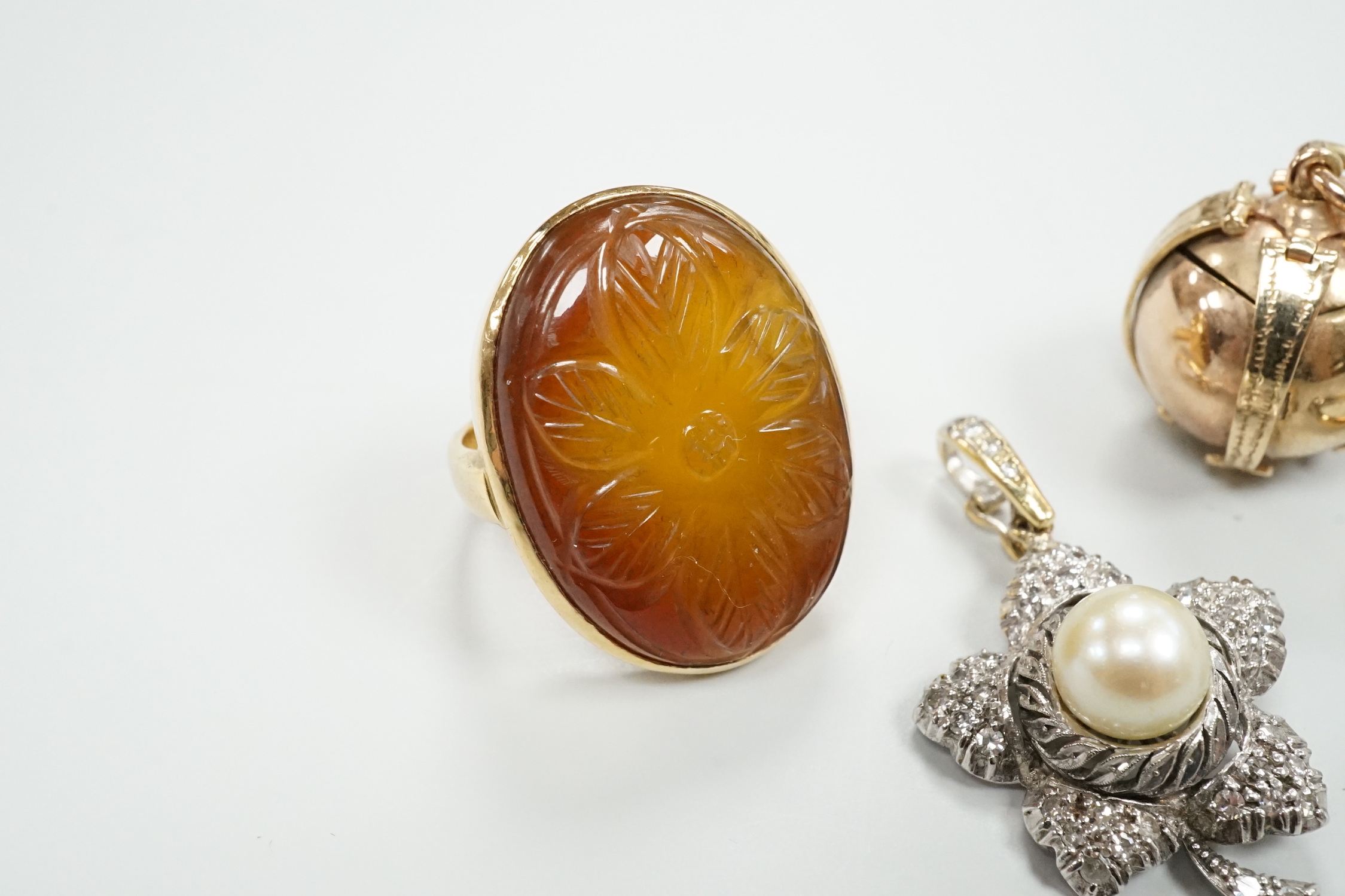A 9ct masonic ball pendant, 18mm, a 750 white metal cultured pearl and diamond chip set flower head pendant, 38mm, a yellow metal ring and an 18ct and illusion set diamond ring.